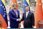 　中国の習近平国家主席（右）と握手するベネズエラのマドゥロ大統領＝１３日、北京の人民大会堂（新華社＝共同）