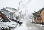 　地震で倒壊した建物に雪が降り積もる石川県珠洲市内＝１３日午前
