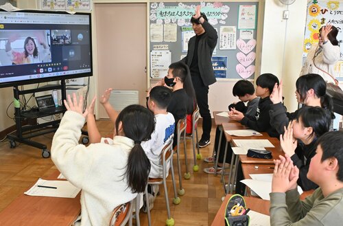 玉城さん（左）とオンラインで交流した児童ら＝２０日、米子市和田町の和田小