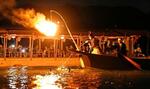 　「長良川鵜飼」が開幕し、かがり火の下でアユを追う鵜匠とウ。観覧船から乗客らが見守った＝１１日夜、岐阜市