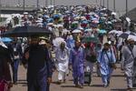 　サウジアラビア・メッカ近郊で日傘を差す巡礼者たち＝１８日（ＡＰ＝共同）