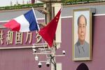 　昨年４月、北京の天安門前に掲げられたフランス（左）と中国の国旗（共同）