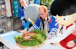 感謝の思いを込めてカニを奉納する越河会長（中央）ら＝１９日、鳥取県境港市大正町の妖怪神社