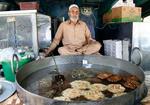 　チャッパル・カバーブを作り続けて４０年以上の料理人リアーカト・カーンさん＝２０２４年６月６日、パキスタン・イスラマバード（共同）