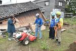 耕運機を取り出した藤野さん（左から２人目）と感謝する依頼者（左端）＝６月５日、石川県珠洲市