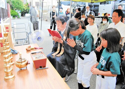 碑前で静かに手を合わせる児童ら＝２５日、大阪市西淀川区の佃小