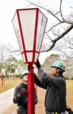 祭りに向けてぼんぼりを設置する作業員＝１３日、米子市西町の湊山公園