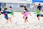 砂浜を全力で駆け回り、サッカーを楽しむ子どもたち＝２６日、新温泉町の浜坂県民サンビーチ