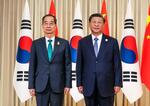 　２３日、中国・杭州で韓国の韓悳洙首相（左）と面会した習近平国家主席（聯合＝共同）