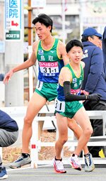 １区大下（左）からたすきを受けた２区亀井が一時は２７位まで順位を押し上げる＝第１中継所