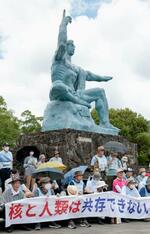 　平和祈念像の前に座り込み、核兵器廃絶などを訴える被爆者ら＝９日、長崎市の平和公園