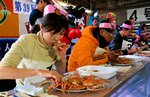 【し烈な争い】
ステージではセコガニをどれだけきれいに食べられるかを競う大会があり、賞品目当てに参加者がし烈な争いを繰り広げた＝香住漁港西港