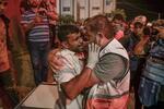 　イスラエル軍の攻撃で父親を亡くし、涙を流す医療関係者（左）＝２１日、パレスチナ自治区ガザ南部ハンユニス（ゲッティ＝共同）
