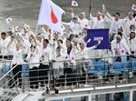 　パリ五輪の開会式で、セーヌ川を船でパレードする日本選手団。（手前左から）旗手の江村美咲、半井重幸＝２６日、パリ（共同）