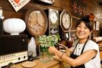 　店内で笑顔を見せる「古道具とれじ」店主の加奈子さん＝７月、富山県滑川市