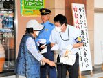 通行人（左）に事件に関する情報提供を呼びかける警察官＝１７日、ＪＲ鳥取駅北口