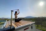 　サウナカーの上で外気浴する冨岡未希さん＝２０２２年４月、青森県内