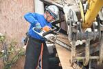 チェーンソーで納屋の板を切り取る藤野さん＝６月５日、石川県珠洲市