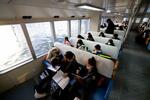 　宮城県・野々島に向かう市営汽船内で読書や課題をこなす児童生徒。通学時の「船勉」は地域の日常風景となっている＝１月