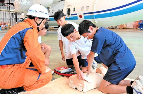 機動救難士（左）から心肺蘇生法やＡＥＤの使い方を学んで実践する生徒たち