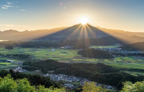 「ダイヤモンド大山」の陽光が降り注ぐ里山＝２０日午前６時１６分、鳥取県南部町福成の母塚山