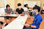 卒業生（右）の経験談を聞く学生ら＝１９日、鳥取市若葉台北１丁目の鳥取環境大