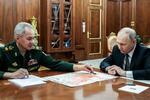 　２月、モスクワの大統領府でショイグ国防相（左）と会談するロシアのプーチン大統領（ロシア大統領府提供・タス＝共同）