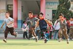 　グラウンドを走る小学生＝３月、中国貴州省（共同）