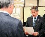 岡本理事長（左）に設置許可証を手渡す盛田部長＝１８日、鳥取県庁