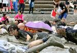 　「鹿島ガタリンピック」で、泥だらけになって競技する「人間むつごろう」の参加者＝２日午後、佐賀県鹿島市