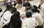 　田奈高の「ぴっかりカフェ」で、大学生のボランティアスタッフ（奥の２人）らとボードゲームをする生徒＝１０月１９日、横浜市
