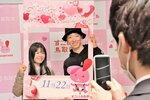 フォトスポットでパネルを持って記念撮影する新婚夫婦＝２２日、鳥取市役所