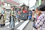 歴史衣装に身を包み、街道を歩く一行と見物する市民ら＝２８日、鳥取市元町の智頭街道