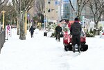 大雪に見舞われ、除雪に追われる市民＝２４日、ＪＲ鳥取駅周辺