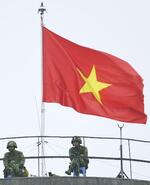 　ハノイ市内で、ベトナム国旗が掲げられた建物の上で警備に当たる兵士＝２０１９年（共同）