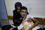 　９日、ガザ南部ハンユニスの病院で、イスラエル軍の空爆でけがをした息子を抱き締める女性（ＡＰ＝共同）