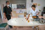 　管理栄養士を務める鶴島綾子（右）、絆診療所の昼ご飯はまかないが多い。この日は震災のときに食べた、固くなったコッペパンでつくったフレンチトーストを配膳する＝２０２４年５月、福島県南相馬市