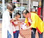 広田市長（右）の呼びかけに応えて募金に協力する買い物客