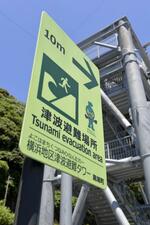 　津波避難場所を示す表示。奥は避難タワー＝２０２０年７月、高知県黒潮町