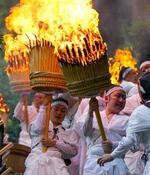 　熊野那智大社の例大祭「那智の扇祭り」で、燃えさかる大たいまつを担ぎ練り歩く白装束の氏子ら＝１４日午後、和歌山県那智勝浦町
