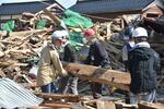 倒壊した建物の木材を運ぶボランティア＝６月４日、石川県珠洲市