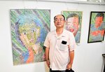 モザイク画を思わせる切手アートの作品を展示する田中さん＝新温泉町春来の春来地区公民館