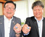 ピンバッジを手に笑顔の広田市長（左）と高橋代表
