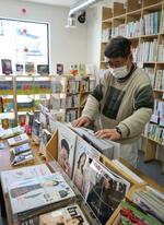 　障害者の就労支援事業所を兼ねた書店「本屋さん　ててたりと」で陳列作業をする店員＝２月、埼玉県川口市