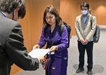 　横浜市議会事務局の担当者（左）に陳情書を手渡すナンミャケーカインさん＝２０２４年５月、横浜市