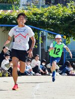 校庭で児童代表チームと競走する川内さん（左）＝３１日、智頭町の智頭小