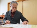 　家賃減免制度に関する書類を見る川名清さん＝２月、仙台市