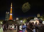 　「ライオンキング」カラーの黄色にライトアップされた東京タワーとドローンによるショー＝２０日夜、東京都港区