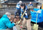 石川県志賀町の住宅敷地内で、屋根瓦などを片付ける鳥取県災害ボランティア隊の隊員ら＝９日（石賀太さん提供）