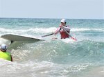 砂浜を駆け、日本海に飛び出す選手ら＝６日、岩美町陸上の東浜海水浴場